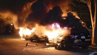 Api melalap deretan mobil polisi yang terparkir di bahu jalan di Atlanta. Mobil itu dibakar oleh warga yang memprotes kematian George Floyd. Ben Gray/Atlanta Journal-Constitution via AP