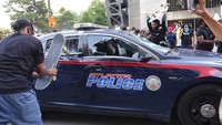Warga merusak mobil polisi dengan memcahkan kacanya. Ben Gray/Atlanta Journal-Constitution via AP.