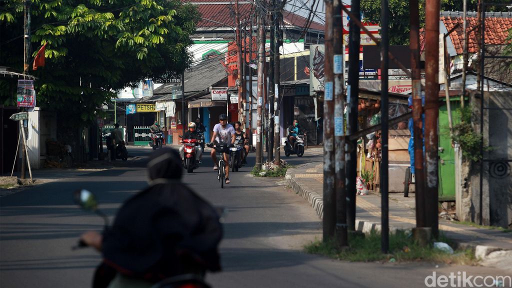 Warga menghindari tiang listrik, telepon maupun kabel serat optik yang berada di badan jalan di Jl WR Supratman, Ciputat Timur, Tangerang Selatan, Sabtu (30/5/2020). Tiang tersebut berada di badan jalan usai proyek pelebaran jalan, pertengahan 2018 lalu. Namun hingga kini belum ada proses pemindahan tiang sehingga membahayakan pengguna jalan. Selain itu, keberadaan tiang tersebut membuat pelebaran jalan belum efektif karena ada penyempitan ruang.