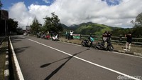 Warga berfoto dengan latar belakang perbukitan di sekitar Gunung Lawu kawasan Cemoro Sewu, Jawa Timur.
