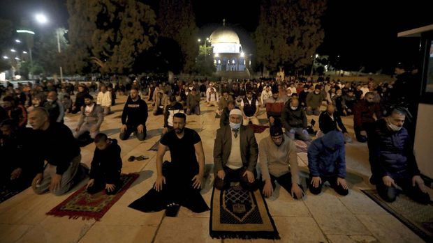 Muslim men pray next to the Dome of the Rock Mosque in the Al Aqsa Mosque compound in Jerusalem's old city, Sunday, May 31, 2020.The Al-Aqsa mosque in Jerusalem, the third holiest site in Islam, reopened early Sunday, following weeks of closure aimed at preventing the spread of the coronavirus. (AP Photo/Mahmoud Illean)