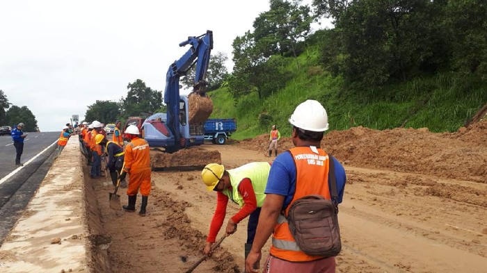 Petugas membersihkan material longsor di Tol Ungaran KM 426+600 lajur Ungaran-Semarang, Minggu (31/5/2020).