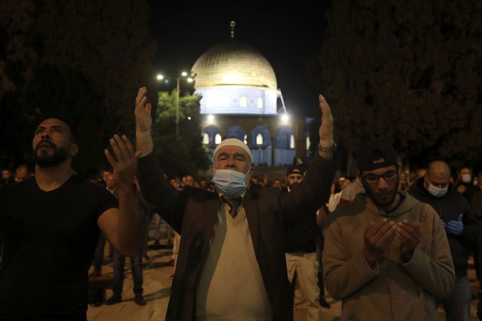 Muslim men pray next to the Dome of the Rock Mosque in the Al Aqsa Mosque compound in Jerusalems old city, Sunday, May 31, 2020.The Al-Aqsa mosque in Jerusalem, the third holiest site in Islam, reopened early Sunday, following weeks of closure aimed at preventing the spread of the coronavirus. (AP Photo/Mahmoud Illean)