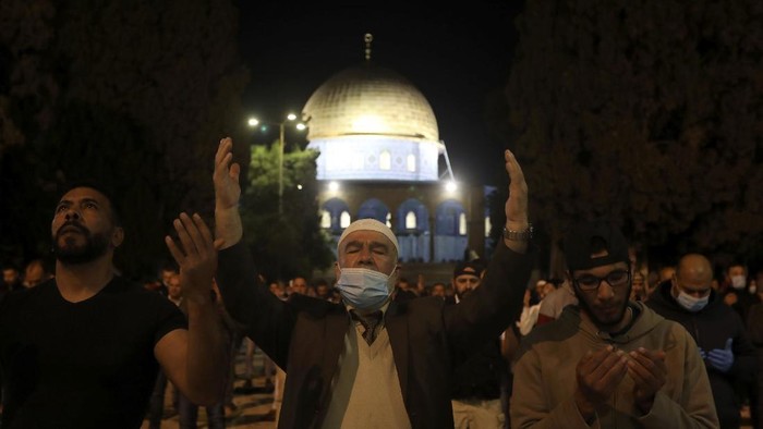 Muslim men pray next to the Dome of the Rock Mosque in the Al Aqsa Mosque compound in Jerusalems old city, Sunday, May 31, 2020.The Al-Aqsa mosque in Jerusalem, the third holiest site in Islam, reopened early Sunday, following weeks of closure aimed at preventing the spread of the coronavirus. (AP Photo/Mahmoud Illean)