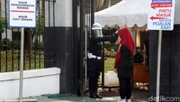 Warga yang akan masuk diperiksa suhu tubuhnya. Jika suhu tubuh 37,5 derajat celcius, warga dilarang masuk.