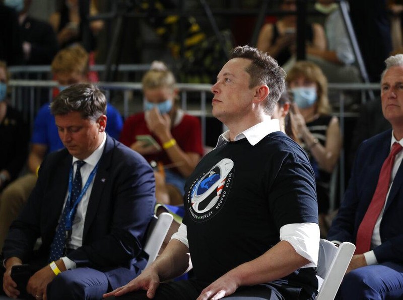 Tesla and SpaceX Chief Executive Officer Elon Musk hugs his brother Kimbal Musk during an event at the Vehicle Assembly Building on Saturday, May 23, 2020, at NASA's Kennedy Space Center in Cape Canaveral, Fla. The event occurred after a rocket ship designed and built by SpaceX lifted off on Saturday with two Americans on a history-making flight to the International Space Station. House Minority Leader Kevin McCarthy of Calif., applauds at right. (AP Photo/Alex Brandon)