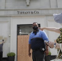 Tak cuma butik pakaian, butik perhiasan juga terdampak. Di foto ini, petugas terlihat membersihkan coretan di dinding depan butik perhiasan Tifanny & Co. (Foto: AP/Marcio Jose Sanchez)