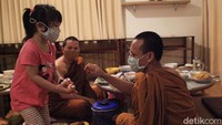 Seorang anak memberikan hadiah kepada Biksu.