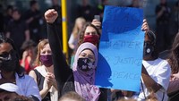 Seorang muslimah di Jerman ikut serta dalam aksi menentang rasisme menyusul kematian George Floyd oleh oknum polisi di Amerika Serikat. Sean Gallup/Getty Images.