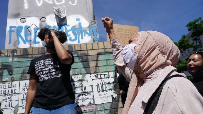 Potret Muslimah Jerman Ikut Demo Dukung George Floyd BERLIN, GERMANY - MAY 31: A Muslim woman wears a face mask that reads: