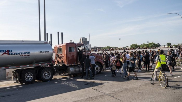 MINNEAPOLIS, MN - MAY 31: People react after a tanker truck drove into a crowd peacefully protesting the death of George Floyd on the I-35W bridge over the Mississippi River on May 31, 2020 in Minneapolis, Minnesota. A large group of protesters had been marching over the bridge on both lanes before a truck drove into the crowd.   Stephen Maturen/Getty Images/AFP