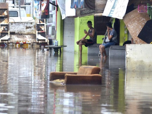 Warga berada di depan tempat tinggalnya saat banjir di kawasan Glogor Carik, Denpasar, Bali, Senin (1/6/2020). Hujan yang mengguyur wilayah Denpasar sejak Minggu (31/5) malam menyebabkan sejumlah titik di Denpasar tergenang air dengan ketinggian bervariasi. ANTARA FOTO/Fikri Yusuf/pras.