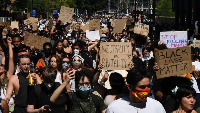 Demonstrators carry placards as they march in the road near the US Embassy in central London on May 31, 2020 to protest the death of George Floyd, an unarmed black man who died after a police officer knelt on his neck for nearly nine minutes during an arrest in Minneapolis, USA. - Hundreds gathered in central London and marched to the US Embassy to protest the death of an unarmed black man in Minneapolis while in police custody that has sparked days of unrest in the US city and beyond. (Photo by DANIEL LEAL-OLIVAS / AFP)
