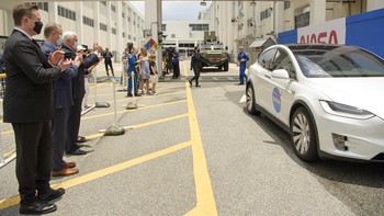 Mereka bertepuk tangan ketika kedua astronaut pergi menggunakan mobil Tesla. Foto: AP/John Raoux