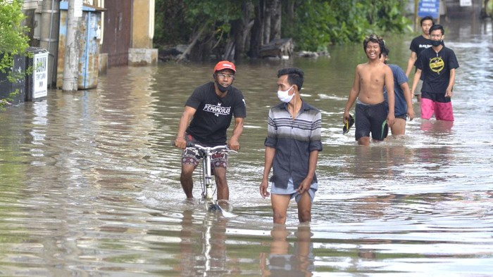 Warga berada di depan tempat tinggalnya saat banjir di kawasan Glogor Carik, Denpasar, Bali, Senin (1/6/2020). Hujan yang mengguyur wilayah Denpasar sejak Minggu (31/5) malam menyebabkan sejumlah titik di Denpasar tergenang air dengan ketinggian bervariasi. ANTARA FOTO/Fikri Yusuf/pras.