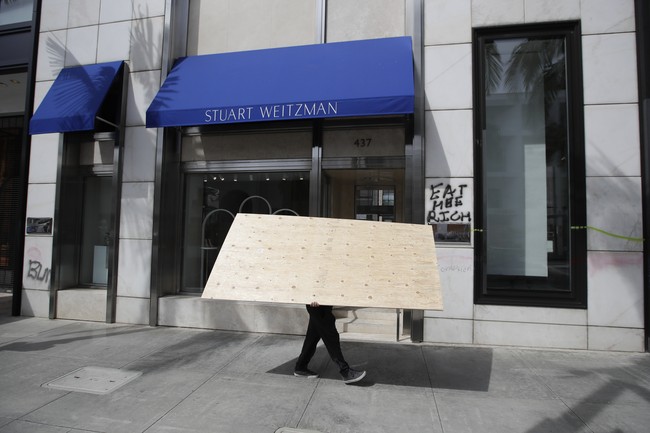 Tulisan yang bernada sarkas, Eat Me Rich, tampak di depan butik merek sepatu Stuart Weitzman yang berada di salah satu sudut Rodeo Drive. (Foto: AP/Marcio Jose Sanchez)