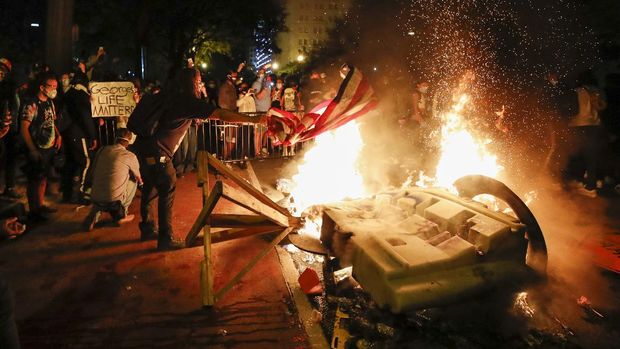 Demonstrators start a fire as they protest the death of George Floyd, Sunday, May 31, 2020, near the White House in Washington. Floyd died after being restrained by Minneapolis police officers (AP Photo/Alex Brandon)