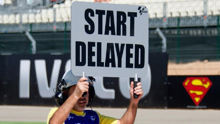 ALCANIZ, SPAIN - SEPTEMBER 16:  A marshall holds a sign aloft indicating a delay to the start of the MotoGP second practice of the Aragon Grand Prix is delayed due to an electrical problem during the MotoGP of Spain at Motorland Aragon Circuit on September 16, 2011 in Alcaniz, Spain.  (Photo by Mirco Lazzari gp/Getty Images)