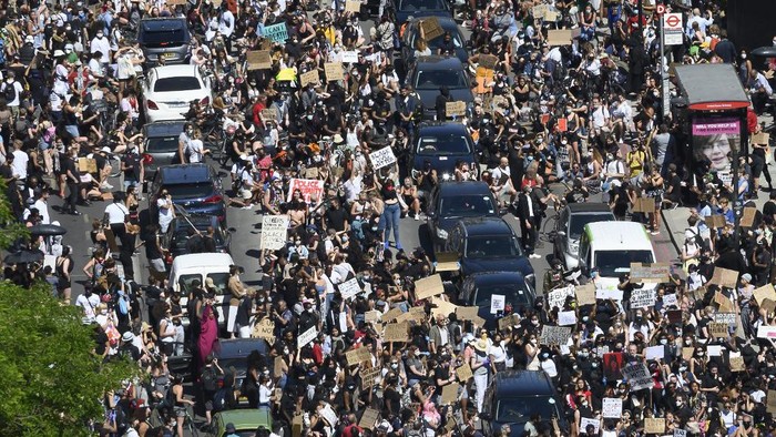 Demonstrators block the road as they gather outside the US Embassy in London on May 31, 2020 to protest the death of George Floyd, an unarmed black man who died after a police officer knelt on his neck for nearly nine minutes during an arrest in Minneapolis, USA. - Hundreds gathered in central London and marched to teh US Embassy to protest the death of an unarmed black man in Minneapolis while in police custody that has sparked days of unrest in the US city and beyond. (Photo by JUSTIN TALLIS / AFP) / The erroneous mention[s] appearing in the metadata of this photo by JUSTIN TALLIS has been modified in AFP systems in the following manner: [London] instead of [Brighton]. Please immediately remove the erroneous mention[s] from all your online services and delete it (them) from your servers. If you have been authorized by AFP to distribute it (them) to third parties, please ensure that the same actions are carried out by them. Failure to promptly comply with these instructions will entail liability on your part for any continued or post notification usage. Therefore we thank you very much for all your attention and prompt action. We are sorry for the inconvenience this notification may cause and remain at your disposal for any further information you may require.