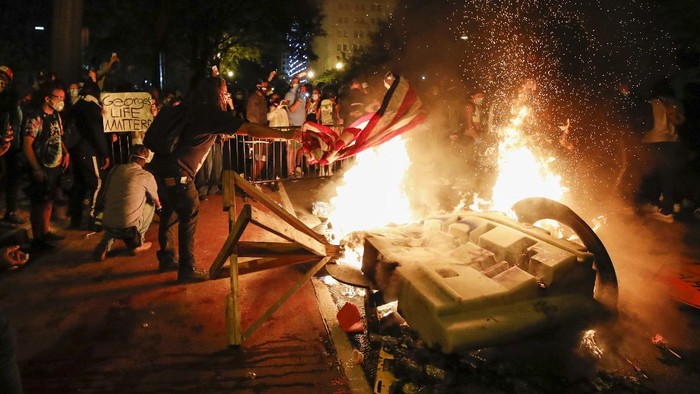 Demonstrators start a fire as they protest the death of George Floyd, Sunday, May 31, 2020, near the White House in Washington. Floyd died after being restrained by Minneapolis police officers (AP Photo/Alex Brandon)