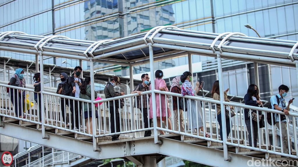 Antrean penumpang bus TransJakarta terlihat di Halte Gatot Subroto. Antrean itu disebabkan oleh warga yang kembali beraktivitas jelang penerapan new normal.