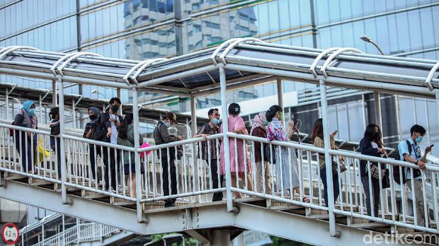 Antrean penumpang bus TransJakarta terlihat di Halte Gatot Subroto. Antrean itu disebabkan oleh warga yang kembali beraktivitas jelang penerapan new normal.