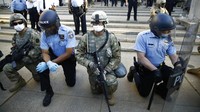 Polisi dan tentara menunjukkan solidaritas untuk para demonstran di luar markas Kepolisian Philadelphia. AP Photo/Matt Rourke.