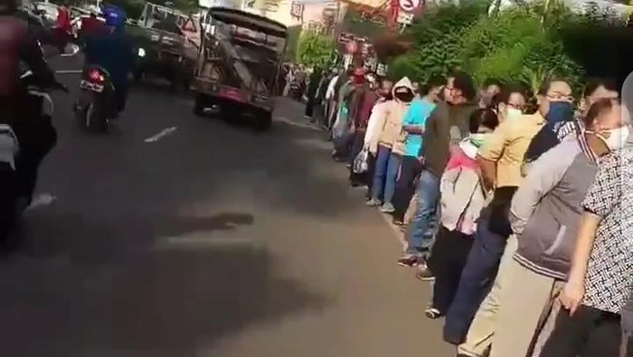 Antrean pemohon mengular hingga ke ruas jalan di depan kantor polisi.