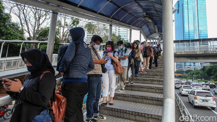 Antrean penumpang bus TransJakarta terlihat di Halte Gatot Subroto. Antrean itu disebabkan oleh warga yang kembali beraktivitas jelang penerapan new normal.