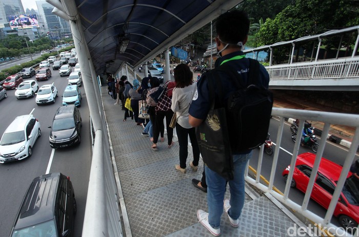 Antrean penumpang bus TransJakarta terlihat di Halte Gatot Subroto. Antrean itu disebabkan oleh warga yang kembali beraktivitas jelang penerapan new normal.
