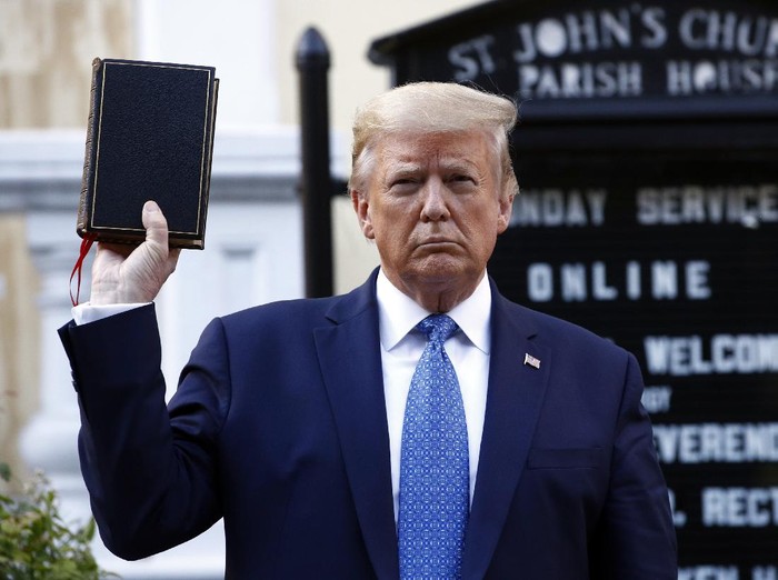 Trump berfoto sambil memegang Alkitab di depan St. Johns Church President Donald Trump holds a Bible as he visits outside St. Johns Church across Lafayette Park from the White House Monday, June 1, 2020, in Washington. Part of the church was set on fire during protests on Sunday night. (AP Photo/Patrick Semansky)