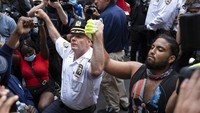 Kepala Departemen Kepolisian Kota New York, Terence Monahan juga berlutut dan bergandengan tangan bersama demonstran. AP Photo/Craig Ruttle.