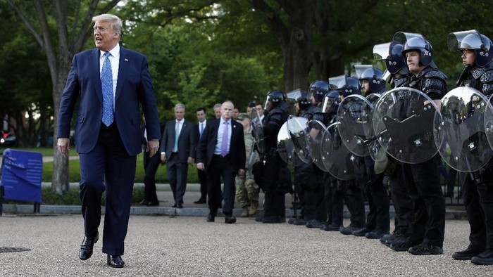 President Donald Trump walks past police in Lafayette Park after he visited outside St. Johns Church across from the White House Monday, June 1, 2020, in Washington. Part of the church was set on fire during protests on Sunday night. (AP Photo/Patrick Semansky)