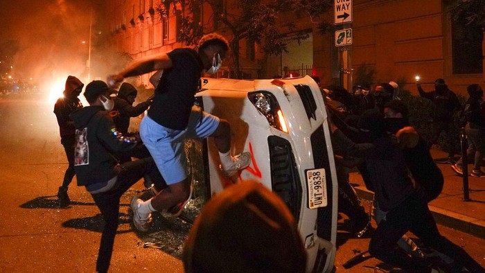 Waduh! Mobil-mobil Ini Rusak Akibat Demo George Floyd Police officers stop to look at a burned out police car, Monday, June 1, 2020, in the SoHo neighbourhood of New York. Protesters burned the car in reaction to George Floyd's death while in police custody on May 25 in Minneapolis. (AP Photo/Mark Lennihan)