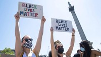 Dua orang demonstran membawa poster bertuliskan Black Lives Matter saat ikut serta dalam aksi unjuk rasa menuntut keadilan untuk George Floyd dan menentang diskriminasi serta rasisme di kawasan Trafalgar Square, London, akhir pekan lalu. Dominic Lipinski/PA via AP.