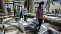 Pengamanan terkait pencegahan penyebaran virus Corona pun turut diterapkan di pusat perbelanjaan. Para pengunjung yang hendak masuk ke dalam mal harus melintasi mesin disinfektan guna mencegah penyebaran virus Corona. AP Photo/Gemunu Amarasinghe.