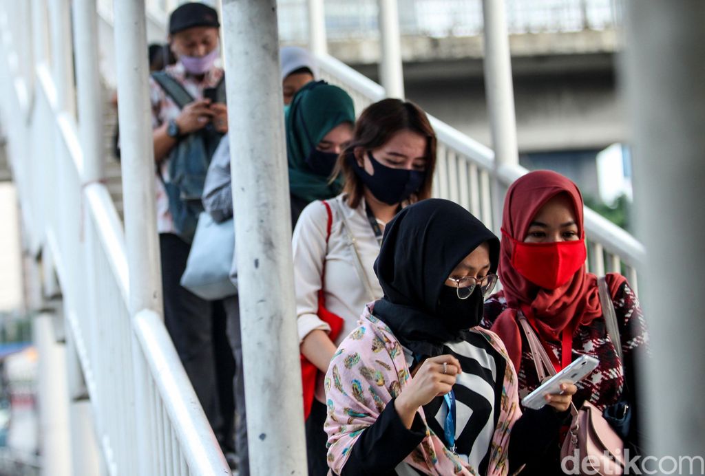 Antrean penumpang bus TransJakarta terlihat di Halte Gatot Subroto. Antrean itu disebabkan oleh warga yang kembali beraktivitas jelang penerapan new normal.