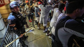 Sekelompok demonstran kulit hitam melindungi polisi yang terpisah dari kelompoknya. Foto: via Bored Panda