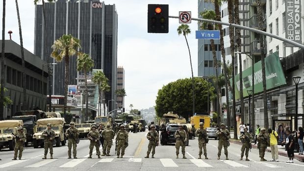 Demonstran menyambut anggota Pengawal Nasional di Amerika Serikat. AP/Ringo H.W. Chiu