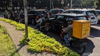 Pengendara menunggu lampu lalu lintas berganti warna.