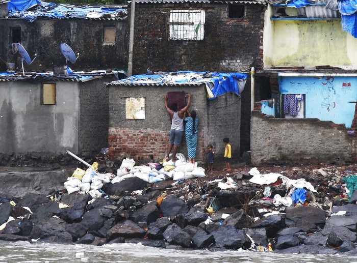 APTOPIX India Cyclone A fisherman's family seals up their window before cyclone Nisarga makes landfall in Mumbai, India, Wednesday, June 3, 2020. A storm in the Arabian Sea off India's west coast intensified into a severe cyclone on Wednesday, gathering speed as it barreled toward India's financial capital of Mumbai. Nisarga was forecast to drop heavy rains and winds gusting up to 120 kilometers (75 miles) per hour when it makes landfall Wednesday afternoon as a category 4 cyclone near the coastal city of Alibagh, about 98 kilometers (60 miles) south of Mumbai, India's Meteorological Department said. (AP Photo/Rajanish Kakade)