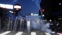 Polisi antihuru-hara melepaskan gas air mata ke arah demonstran saat penerapan jam malam di Atlanta pada 2 Juni 2020. AP Photo/John Bazemore.