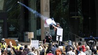 Seorang polisi juga menembakkan gas air mata ke arah kerumunan pengunjuk rasa yang mencari keadilan terkait kematian George Floyd di Cleveland. John Kuntz/The Plain Dealer via AP.