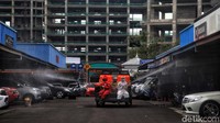 Petugas PMI menyisir berbagai area di kawasan Pasar Mobil Kemayoran untuk melakukan penyemprotan disinfektan.