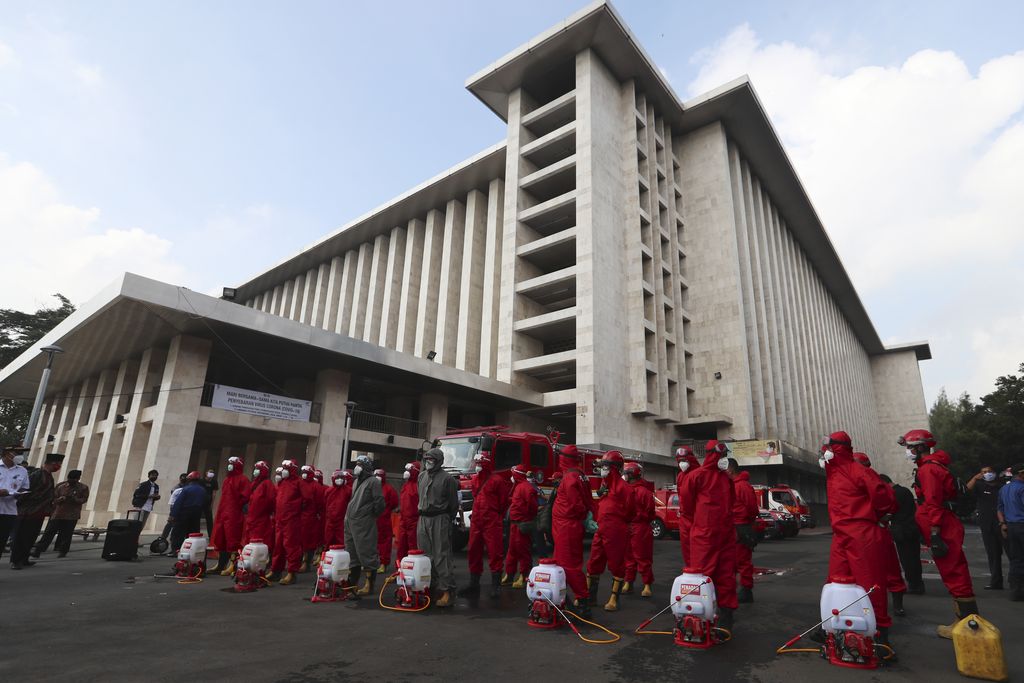 Seorang petugas pemadam kebakaran menyemprotkan desinfektan dalam upaya membantu mengekang penyebaran virus corona baru di Masjid Istiqlal di Jakarta. AP/Achmad Ibrahim