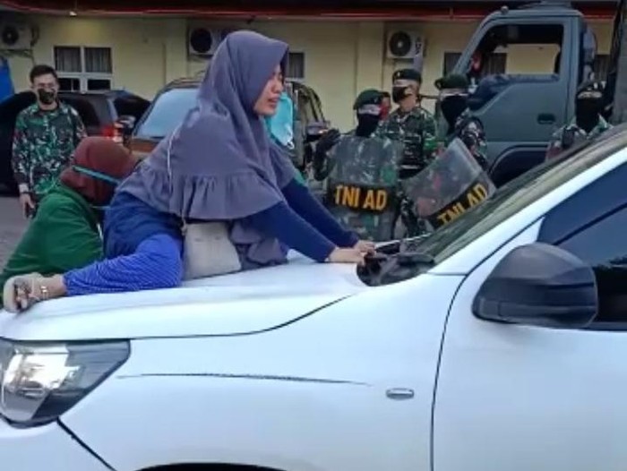 Seorang wanita di Makassar naik ke atas mobil jenazah memohon agar ibunya tidak dimakamkan dengan protokol COVID-19 (dok. Istimewa).