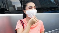 Ia pun tampak membenarkan maskernya kala berpose di depan kamera. Pool/Noel/detikFoto.