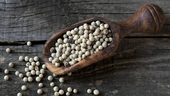 White pepper in wooden spoon