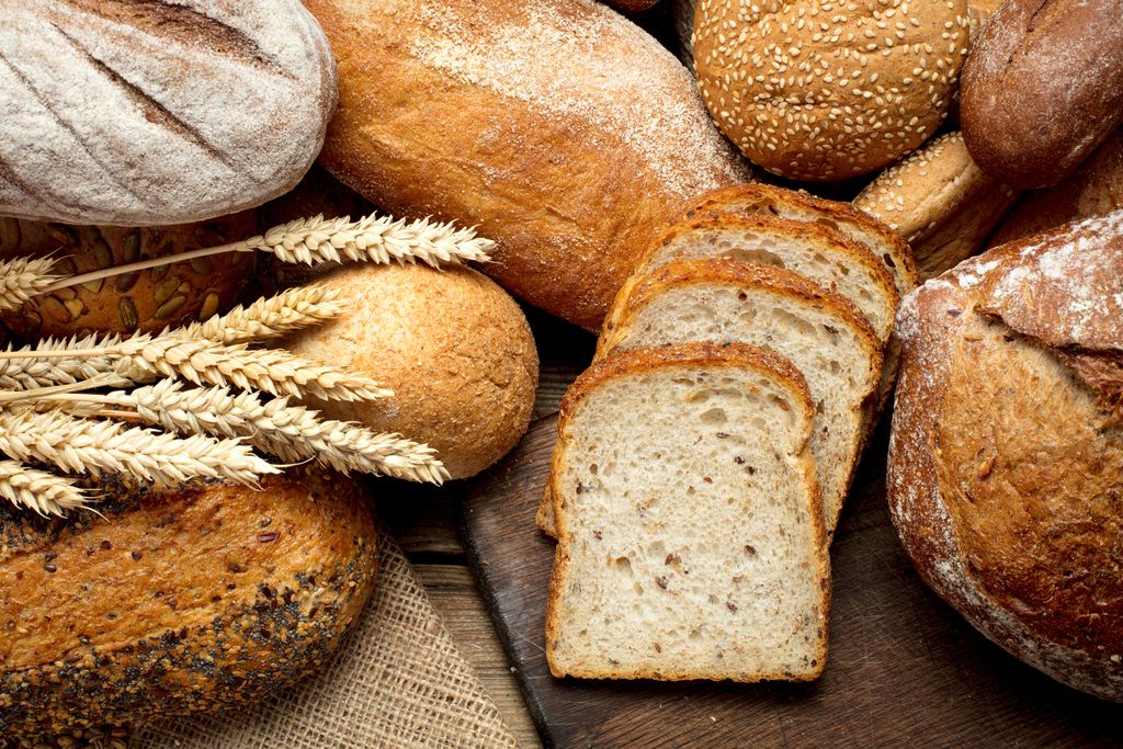 heap of various bread on wooden background