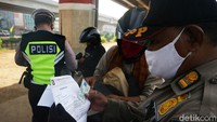 Petugas memeriksa surat tugas hingga identitas pengendara yang akan memasuki wilayah DKI Jakarta.